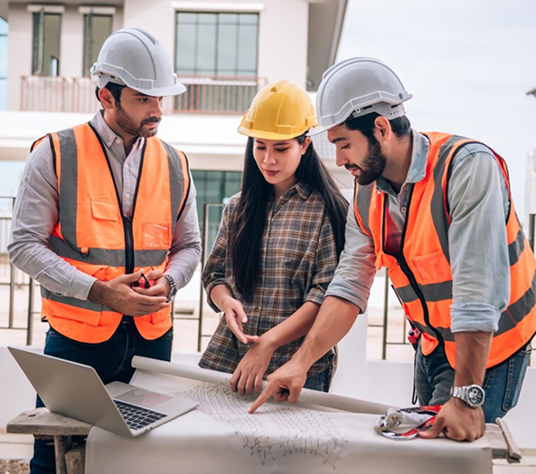 Engineers discussing a blueprint at a construction site.